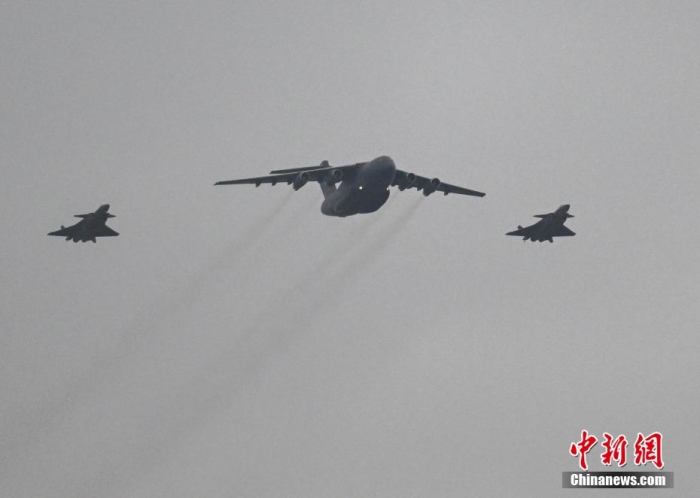 11月23日，第十批在韓中國人民志愿軍烈士遺骸迎回儀式在沈陽桃仙國際機場舉行。儀式結(jié)束后，志愿軍烈士遺骸棺槨被護送前往沈陽抗美援朝烈士陵園。今年是抗美援朝戰(zhàn)爭勝利70周年，也是在韓中國人民志愿軍烈士遺骸歸國安葬的第十年。2014年至2023年，10批共938位在韓中國人民志愿軍烈士遺骸歸國，并長眠于沈陽抗美援朝烈士陵園。圖為搭載著25位志愿軍烈士遺骸及相關遺物的運-20運輸機在兩架殲-20飛機伴飛護航下，飛臨沈陽桃仙國際機場上空。<a target='_blank' href='/' >中新網(wǎng)</a>記者 于海洋 攝