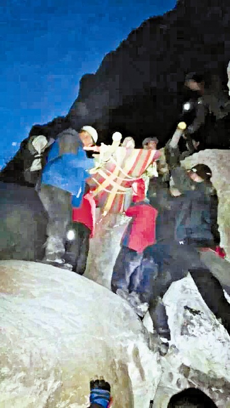 救援隊員用自制的簡易擔(dān)架抬傷者。