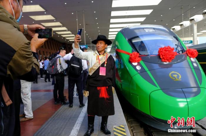 2021年6月25日，川藏鐵路拉林段(拉林鐵路)正式開通運營，復興號高原內電雙源動車組同步投入運營。拉林鐵路全長48公里，設計時速160公里。這是西藏首條電氣化鐵路，也是復興號動車組首次開進西藏。圖為當日，民眾在拉薩火車站復興號車頭前拍照留念。 <a target='_blank' href='/'>中新社</a>記者 江飛波 攝