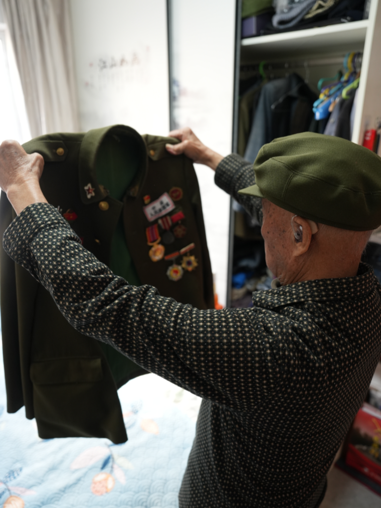 李維波老人整理軍裝。人民網(wǎng)記者 周頌雪攝